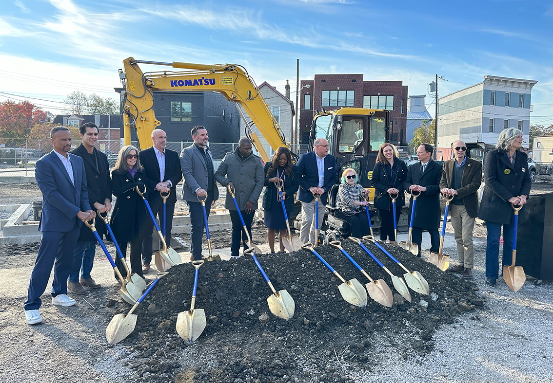 group of people standing with shovels for a breaking ground ceremony