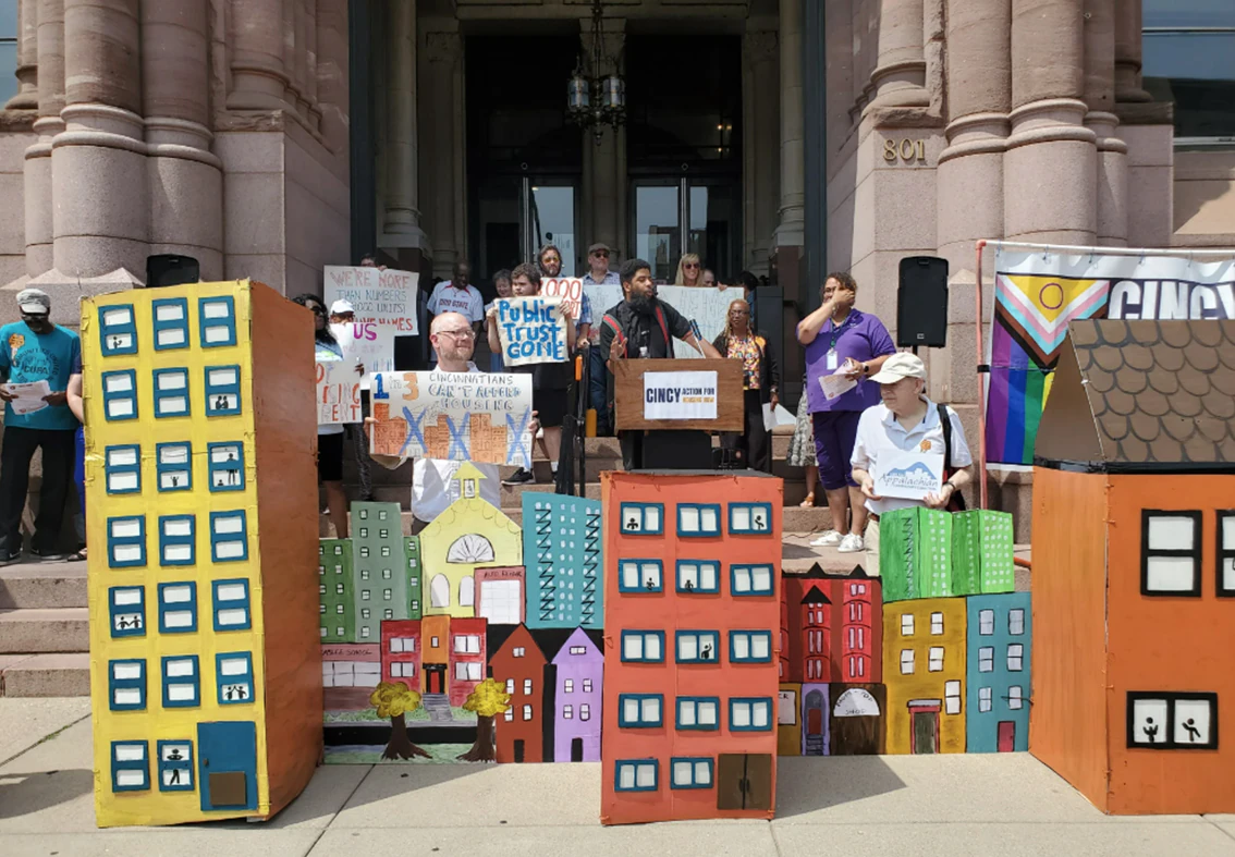 City hall protest with large cardboard housing replicas