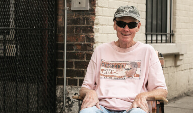 man sitting outside his home